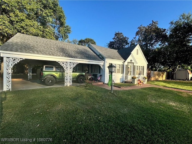 rear view of property featuring a storage shed, fence, an outdoor structure, a yard, and roof with shingles