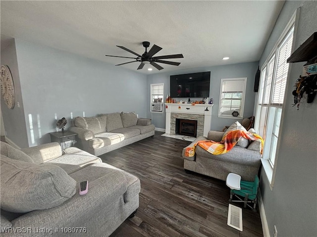 420 Wheeler Ave, Sallisaw, OK 74955 - living area with visible vents, a wealth of natural light, dark wood-style floors, a ceiling fan, and a tile fireplace