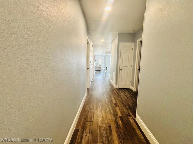 420 Wheeler Ave, Sallisaw, OK 74955 - corridor featuring a textured wall, baseboards, and dark wood-type flooring