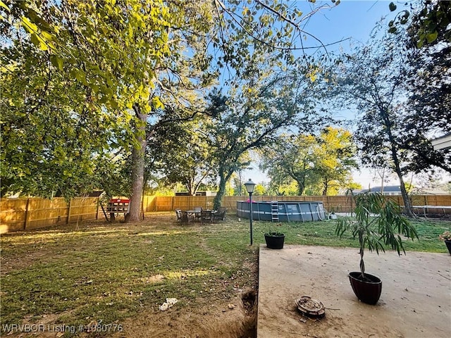 view of yard featuring a patio area, a fenced backyard, and a fenced in pool