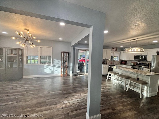420 Wheeler Ave, Sallisaw, OK 74955 - living room featuring dark wood finished floors, an inviting chandelier, a textured ceiling, and recessed lighting