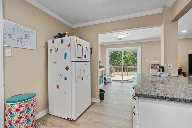 2128 N 53rd St, Fort Smith, AR 72904 - kitchen featuring freestanding refrigerator, light wood-style floors, ornamental molding, dark stone countertops, and baseboards