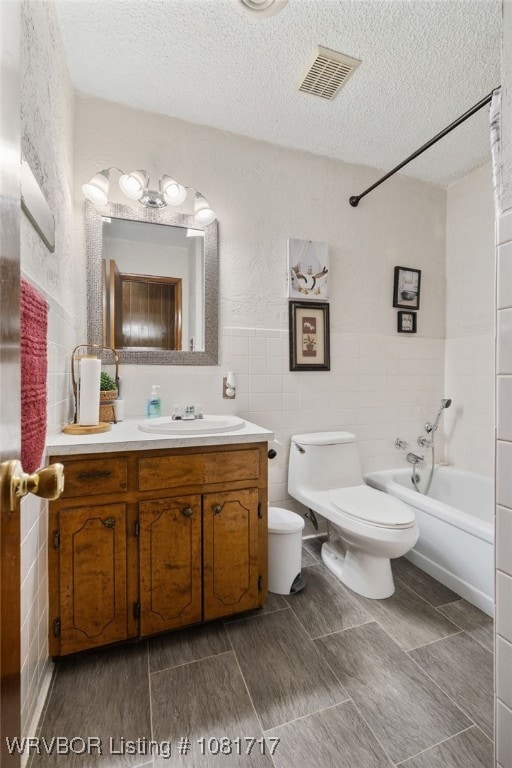 406 Hamilton St, Poteau, OK 74953 - bathroom featuring vanity, a textured ceiling, shower / tub combination, and tile walls