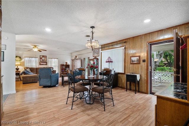 406 Hamilton St, Poteau, OK 74953 - dining room featuring plenty of natural light, light wood-type flooring, a textured ceiling, wood walls, and a ceiling fan