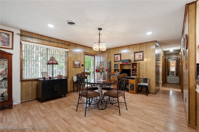406 Hamilton St, Poteau, OK 74953 - dining area featuring wooden walls, light wood-style flooring, a chandelier, recessed lighting, and a textured ceiling