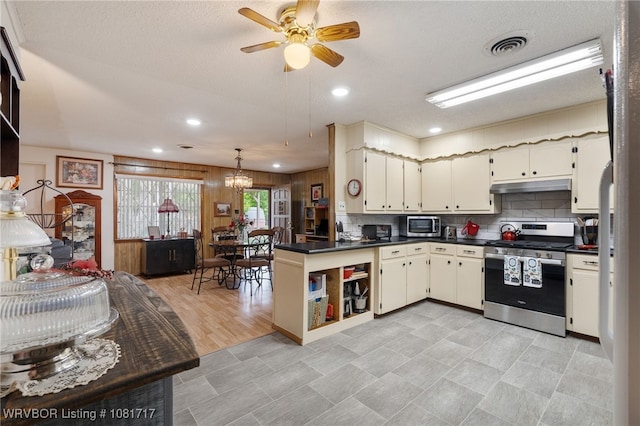 406 Hamilton St, Poteau, OK 74953 - kitchen featuring stainless steel appliances, under cabinet range hood, dark countertops, a peninsula, and tasteful backsplash