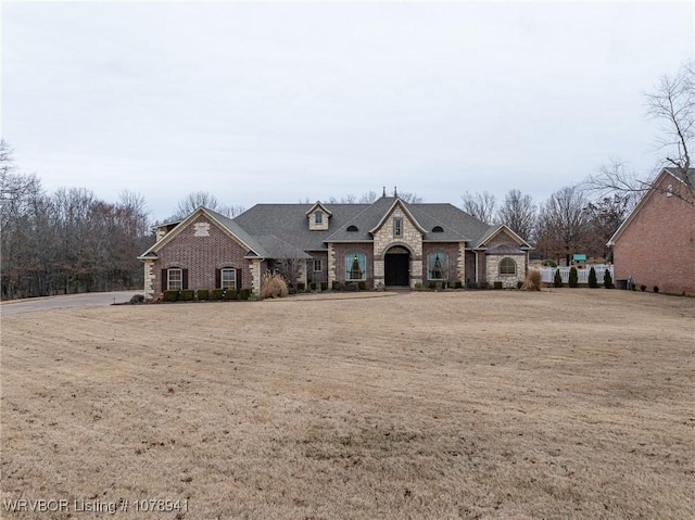 french provincial home with a front yard