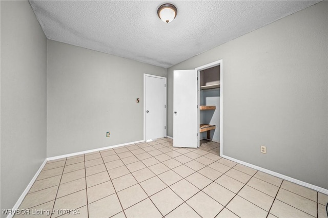 unfurnished bedroom with a closet, a textured ceiling, and baseboards