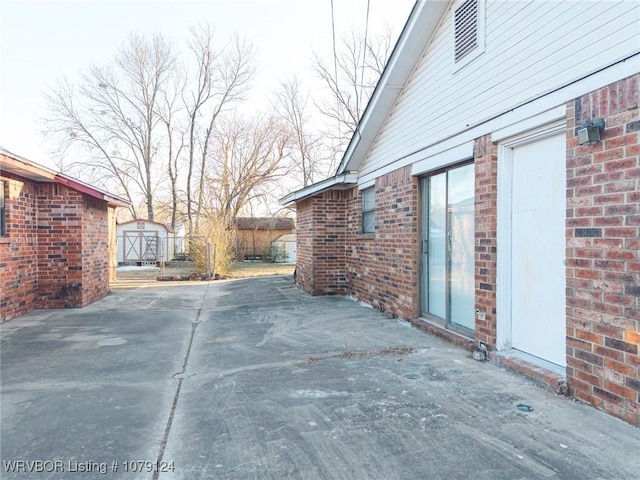 view of patio with an outbuilding and a storage unit