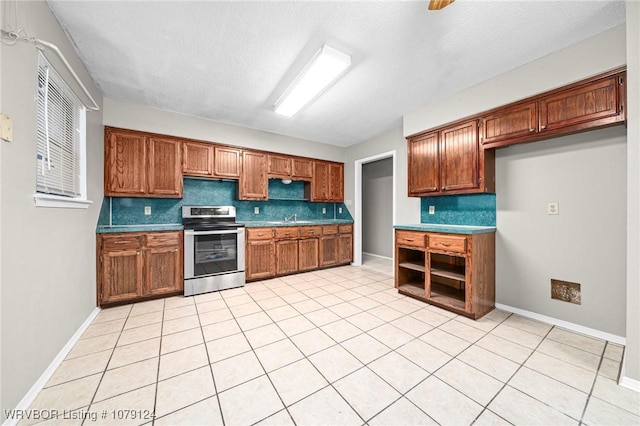 kitchen featuring brown cabinetry, dark countertops, stainless steel electric range, and tasteful backsplash