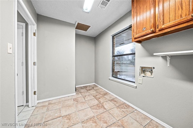 washroom featuring hookup for a washing machine, cabinet space, visible vents, a textured ceiling, and baseboards