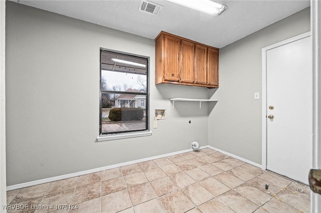 clothes washing area with hookup for a washing machine, hookup for an electric dryer, visible vents, baseboards, and cabinet space