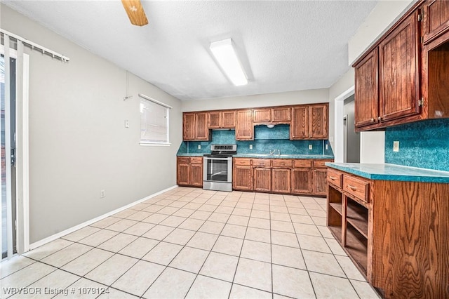 kitchen featuring tasteful backsplash, brown cabinets, stainless steel electric range, and light tile patterned flooring