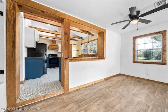 unfurnished living room with ceiling fan, sink, and hardwood / wood-style flooring