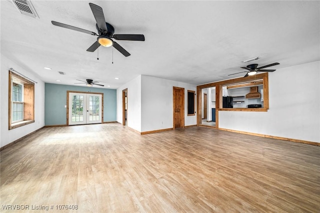 unfurnished living room with hardwood / wood-style floors, ceiling fan, and french doors