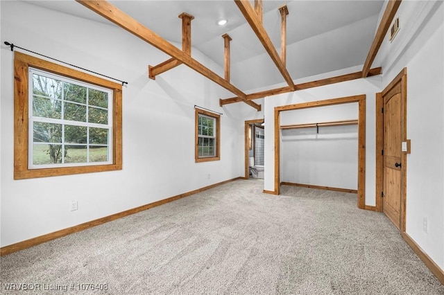 unfurnished bedroom featuring vaulted ceiling, carpet floors, and a closet