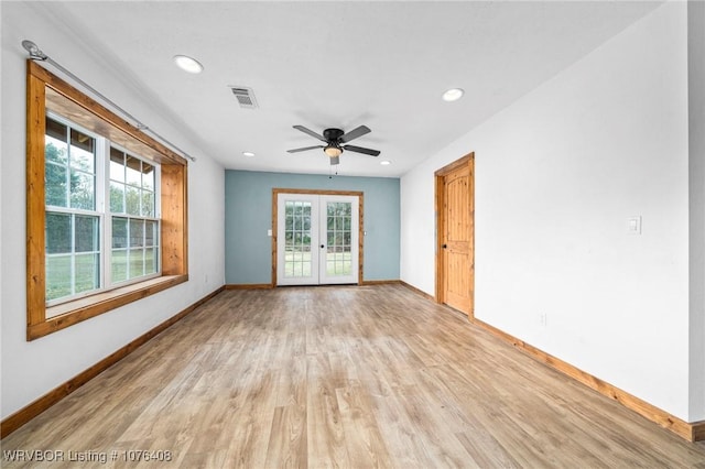 empty room with ceiling fan, light hardwood / wood-style flooring, and french doors