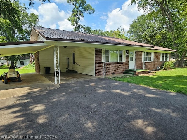 ranch-style home featuring a front lawn and a carport