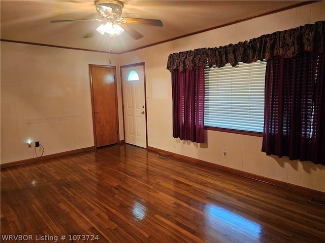 unfurnished room featuring dark wood-type flooring, ceiling fan, and ornamental molding