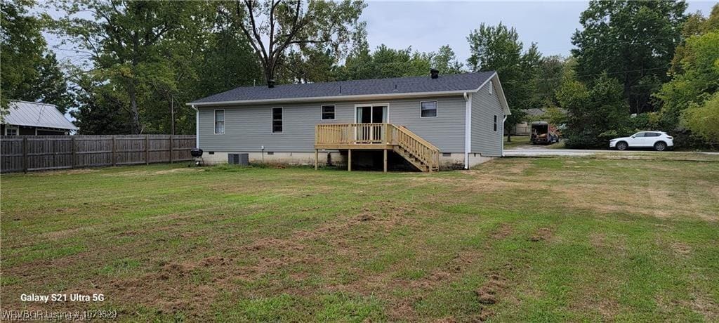 back of property with fence, a yard, central AC, stairs, and crawl space