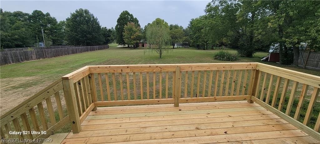 deck featuring a lawn and fence