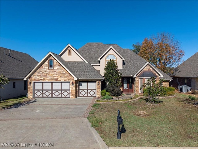 view of front facade with a front yard, central AC unit, and a garage