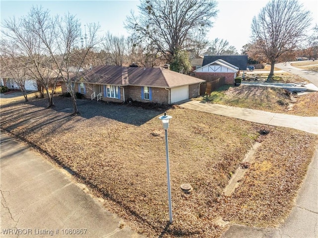 view of front of home featuring driveway, brick siding, and an attached garage
