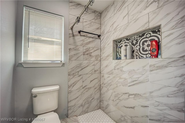 full bathroom with tiled shower and toilet