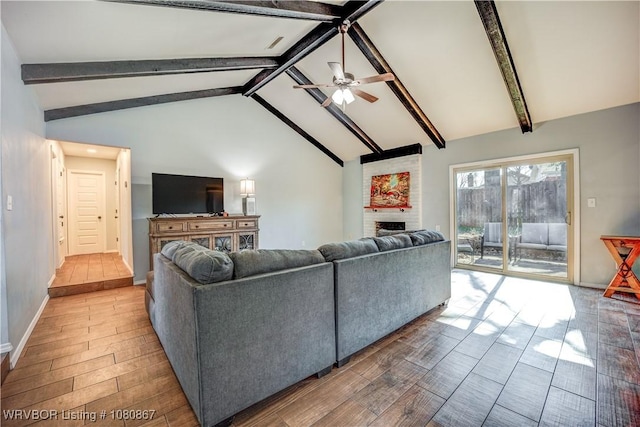 living room with a fireplace, ceiling fan, beam ceiling, wood finished floors, and baseboards