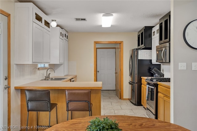 103 Bowlin Dr, Poteau, OK 74953 - kitchen with appliances with stainless steel finishes, backsplash, glass insert cabinets, and white cabinets