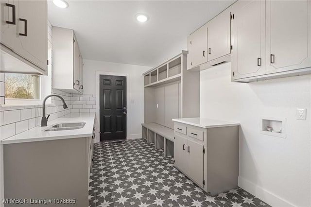 clothes washing area with washer hookup, sink, and cabinets