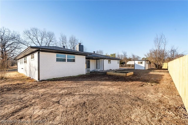 rear view of house with a storage shed