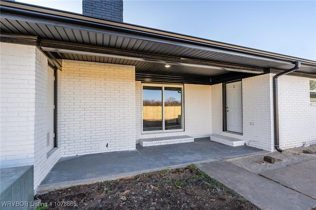 property entrance featuring cooling unit and a patio