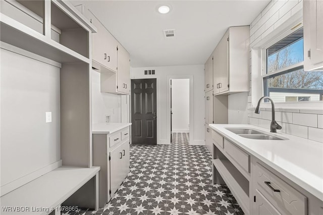 kitchen with white cabinetry, sink, and decorative backsplash