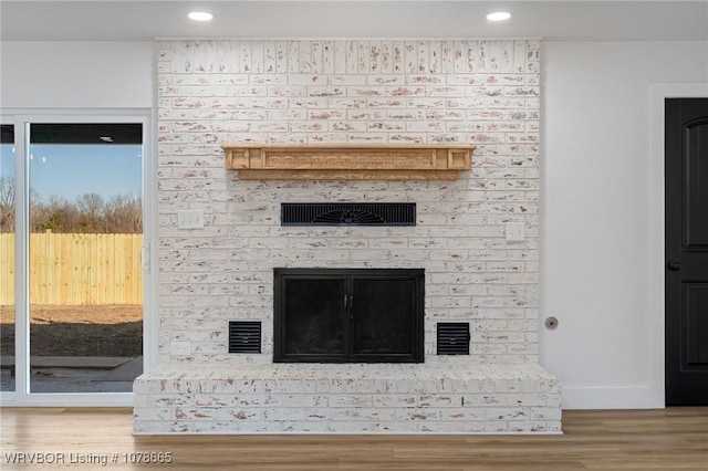 interior details featuring a fireplace and wood-type flooring