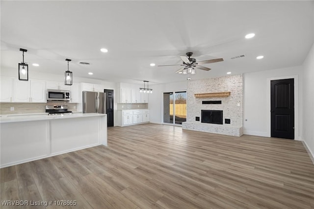 unfurnished living room with a fireplace, light hardwood / wood-style floors, and ceiling fan