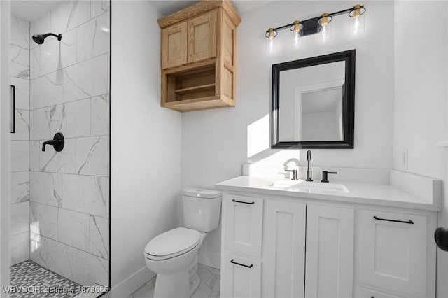 bathroom with vanity, toilet, and a tile shower