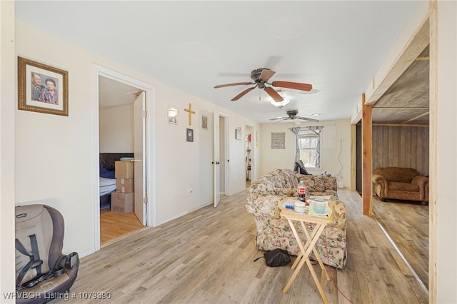 living area with light wood-type flooring and a ceiling fan