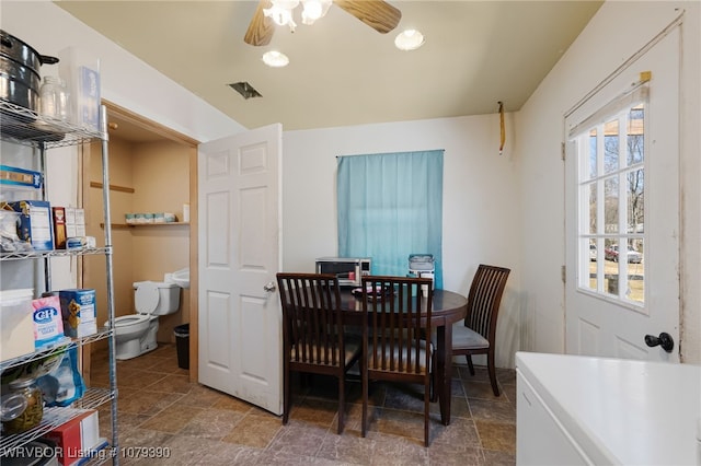 dining space featuring stone finish flooring and a ceiling fan