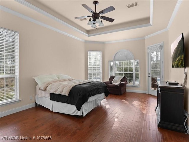 bedroom with dark hardwood / wood-style flooring, access to outside, ceiling fan, a raised ceiling, and crown molding