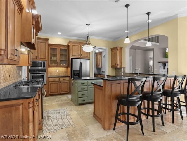 kitchen with tasteful backsplash, a center island, hanging light fixtures, appliances with stainless steel finishes, and kitchen peninsula