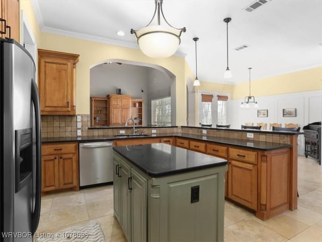 kitchen with sink, appliances with stainless steel finishes, kitchen peninsula, a kitchen island, and pendant lighting