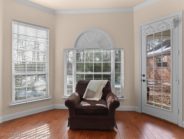 living area with crown molding and wood-type flooring