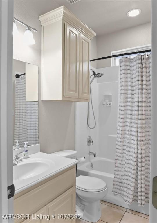 full bathroom with tile patterned flooring, toilet, vanity, and shower / bath combo with shower curtain