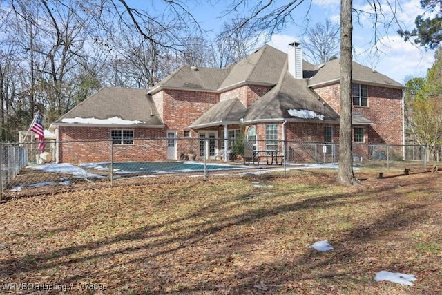 back of property with a yard, a patio, and a covered pool