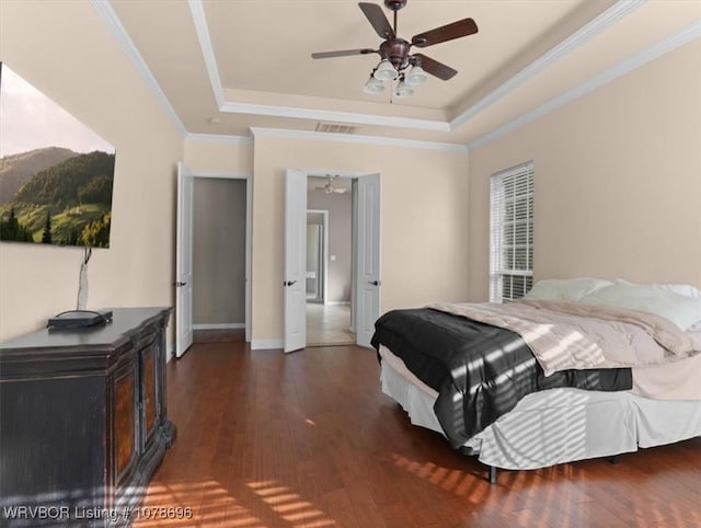 bedroom featuring a raised ceiling, ornamental molding, dark hardwood / wood-style floors, and ceiling fan