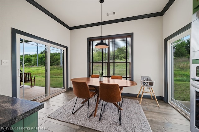 dining space with ornamental molding and a wealth of natural light