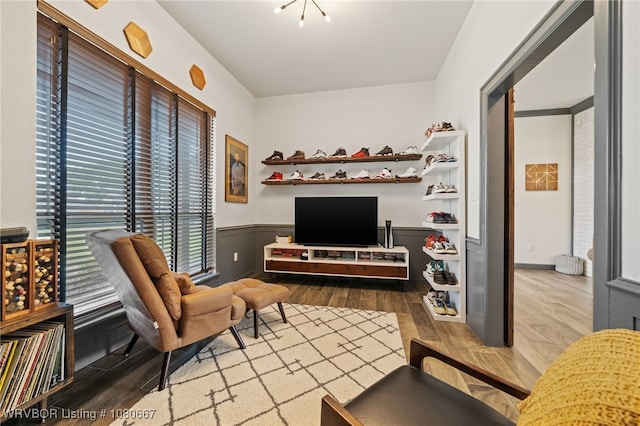 sitting room with wood finished floors and a wainscoted wall