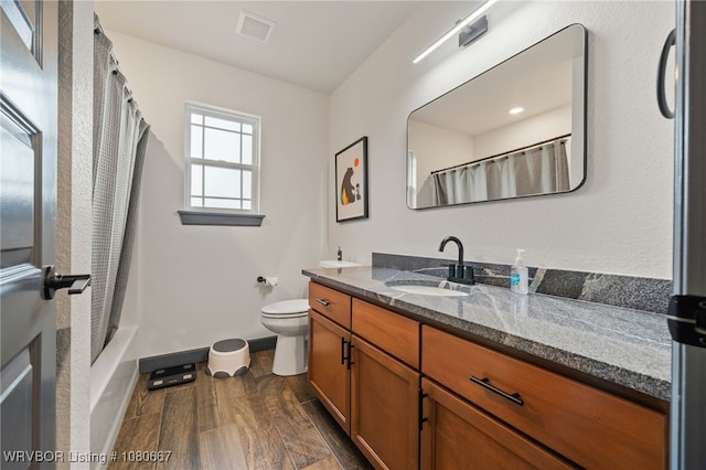 full bathroom featuring visible vents, wood finished floors, baseboards, vanity, and toilet