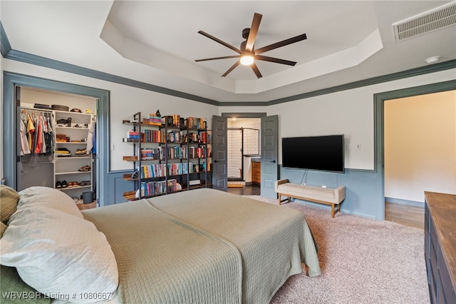 carpeted bedroom with a tray ceiling, visible vents, a spacious closet, and a closet